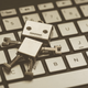 A small robot lying prone on a keyboard.